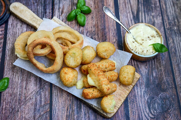 Selection of fast food snack. italian cheese breaded Mozzarella Sticks, Jalapeno Cheese nuggets, Onion Rings and mayo sauce.Italian street junk food