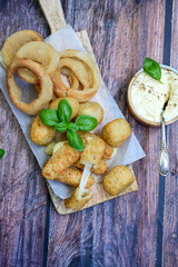 Selection of fast food snack. italian cheese breaded Mozzarella Sticks, Jalapeno Cheese nuggets, Onion Rings and mayo sauce.Italian street junk food