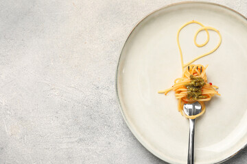 Heart made with spaghetti and fork on grey table, top view. Space for text