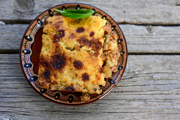  Bulgarian moussaka.Potato and minced meat  Casserole  with   parmesan cheese and garlic on wooden rustic bakcground.  