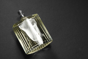 Luxury men`s perfume in bottle on black background, above view. Space for text