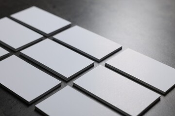 Blank business cards on grey textured table, closeup. Mockup for design