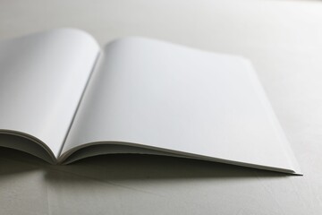 Open notebook with blank pages on grey textured table, closeup. Mockup for design