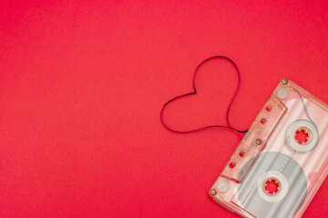 An old vintage cassette tape with the tape being pulled out in the shape of two love hearts on a...