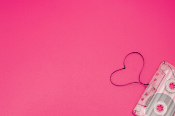 An old vintage cassette tape with the tape being pulled out in the shape of two love hearts on a...