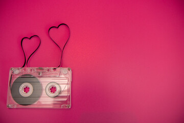 An old vintage cassette tape with the tape being pulled out in the shape of two love hearts on a...