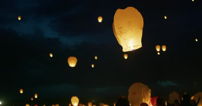 Low shot beneath Chinese lantern rising into night sky