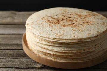 Stack of tasty homemade tortillas on wooden table