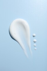Sample of face cream on light blue background, top view