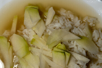 Boiled jasmine rice in broth sprinkled with thin slices of kohlrabi