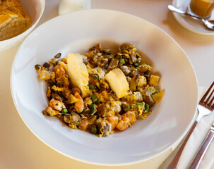 Appetizing scrambled eggs with mushrooms and shrimp served on platter