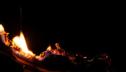 burning paper, glowing edge of paper on a black background.