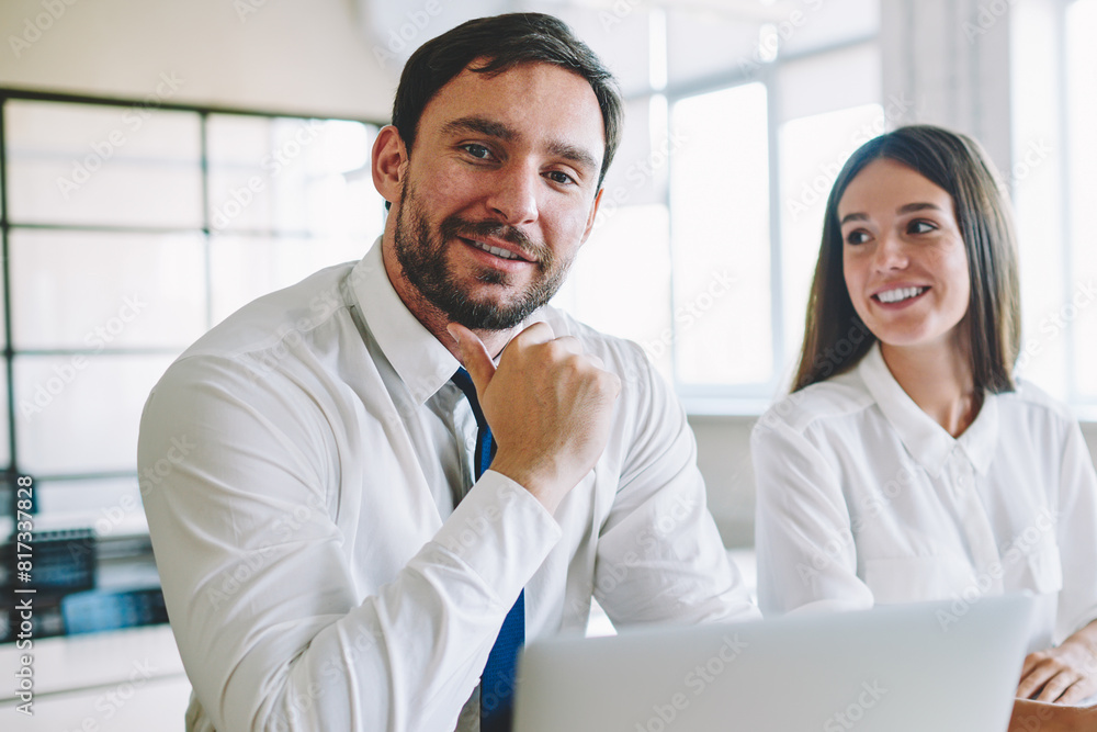 Poster portrait of successful positive male professional architect sitting at desktop with laptop computer 