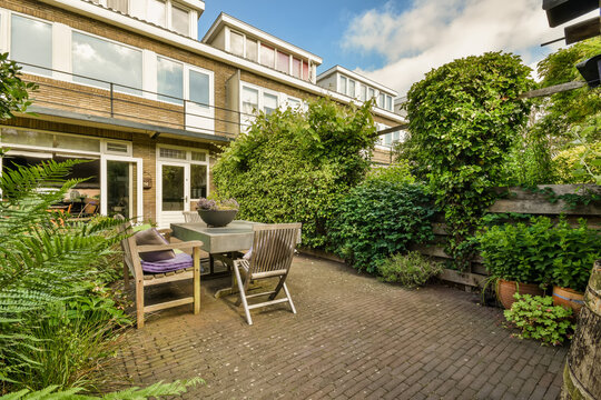 Cozy Backyard Patio with Lush Greenery and Modern Furniture