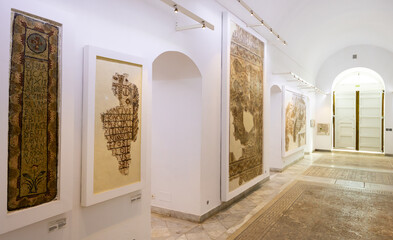 Obraz premium TUNIS, TUNISIA - APRIL 02, 2024: Hall of Bardo National Museum with fragments of surviving Roman floor and wall mosaics unearthed from ancient cities across country, showcasing cultural heritage