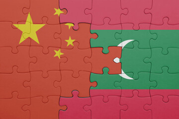puzzle with the colourful national flag of maldives and flag of china .