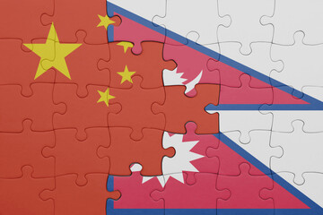 puzzle with the colourful national flag of nepal and flag of china .