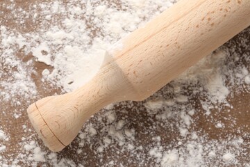 Scattered flour and rolling pin on wooden table, top view