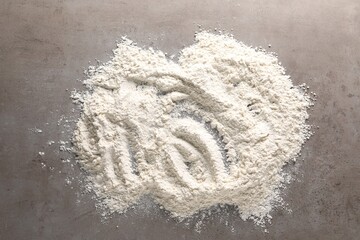 Pile of flour on grey textured table, top view