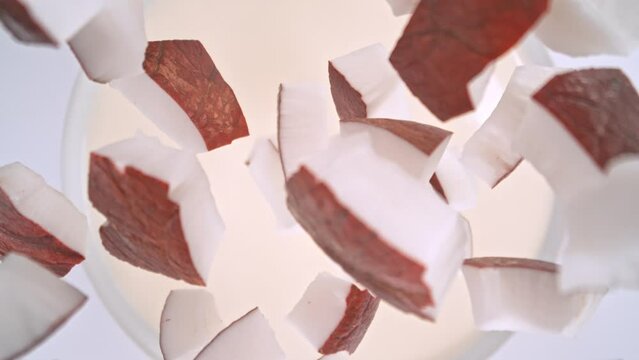 Super Slow Motion Shot of Coconut Cuts Followed by Camera Falling into Milk at 1000fps.