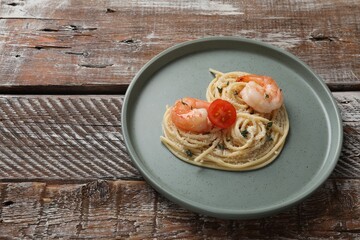 Heart made of tasty spaghetti, tomato, shrimps and cheese on wooden table. Space for text