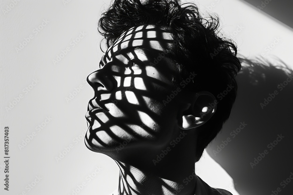 Poster simplistic yet compelling image of a man's shadowed profile with sharp shadows on a plain wall