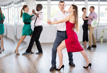 With unhurried music, man with woman in couple spins to rhythm of waltz during lesson for novice...