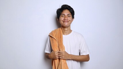 Young Asian man is happy in a white shirt and towel