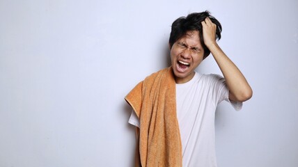 young asian man in white shirt and towel expression of headache, stress, depression, frustration...
