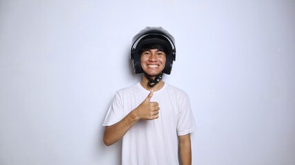 Excited young Asian man in white shirt gesturing with a helmet and thumbs up