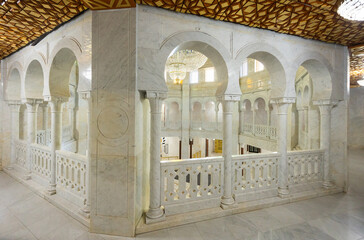 Interior of tomb mausoleum of Habib Bourguiba. White marble walls and lattice windows under arches...