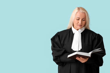 Mature female judge with book on grey background