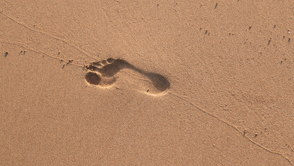 A foot print is in the sand