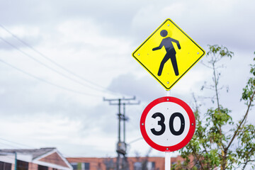 Caution traffic signs with the crossing of people and maximum speed of 30 kilometers