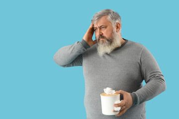 Portrait of sad senior man with tissues on blue background