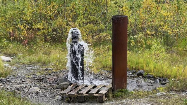 An underground geyser in Khibiny. Lake Maly Woodyavr. The purest water comes out of the ground. Valley of geysers. A thermal spring located in the middle of an endless valley, in a mountainous area.4К