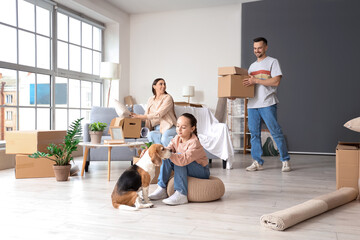 Happy family with Beagle dog packing things in room on moving day