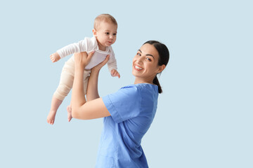 Female pediatrician with little baby on blue background