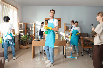 Group of janitors cleaning in office