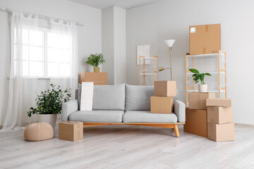 Cardboard boxes and furniture prepared for house moving in light living room
