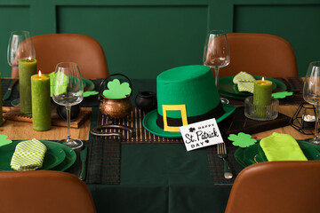 Festive table serving with leprechaun's hat and burning candles. St. Patrick's Day celebration