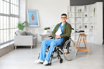 Young male doctor in wheelchair with clipboard at hospital