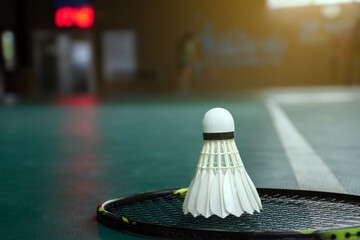 Badminton sport equipments, rackets and shuttlecocks on dark floor of indoor badminton court, soft focus, concept for badminton playing lovers around the world, copy space.