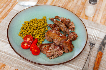 Simple dish of pieces tender young beef veal meat is complemented with cherry tomato and green...