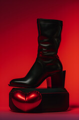 black boot and red heart.Minimal creative fashion concept.Trendy social mockup or wallpaper with copy space.advertisement for shoe stores and footwear industry entities