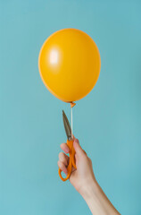 Hand holding a balloon and scissors.Minimal creative fun and party concept.