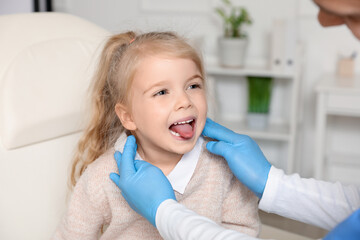 Pediatrician examining little girl in clinic, closeup