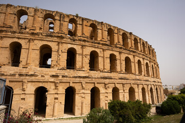 Naklejka premium Scenic view of well-preserved grand El Jem Amphitheatre in Tunisia, showcasing magnificence of Roman architecture, towering against clear blue sky