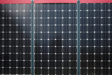 A detailed close-up image of three solar panels arranged in a row, capturing the intricate design...