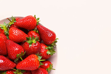 Plate with sweet fresh strawberries on pink background